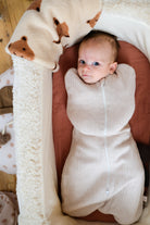 bébé emmailloté dans couffin