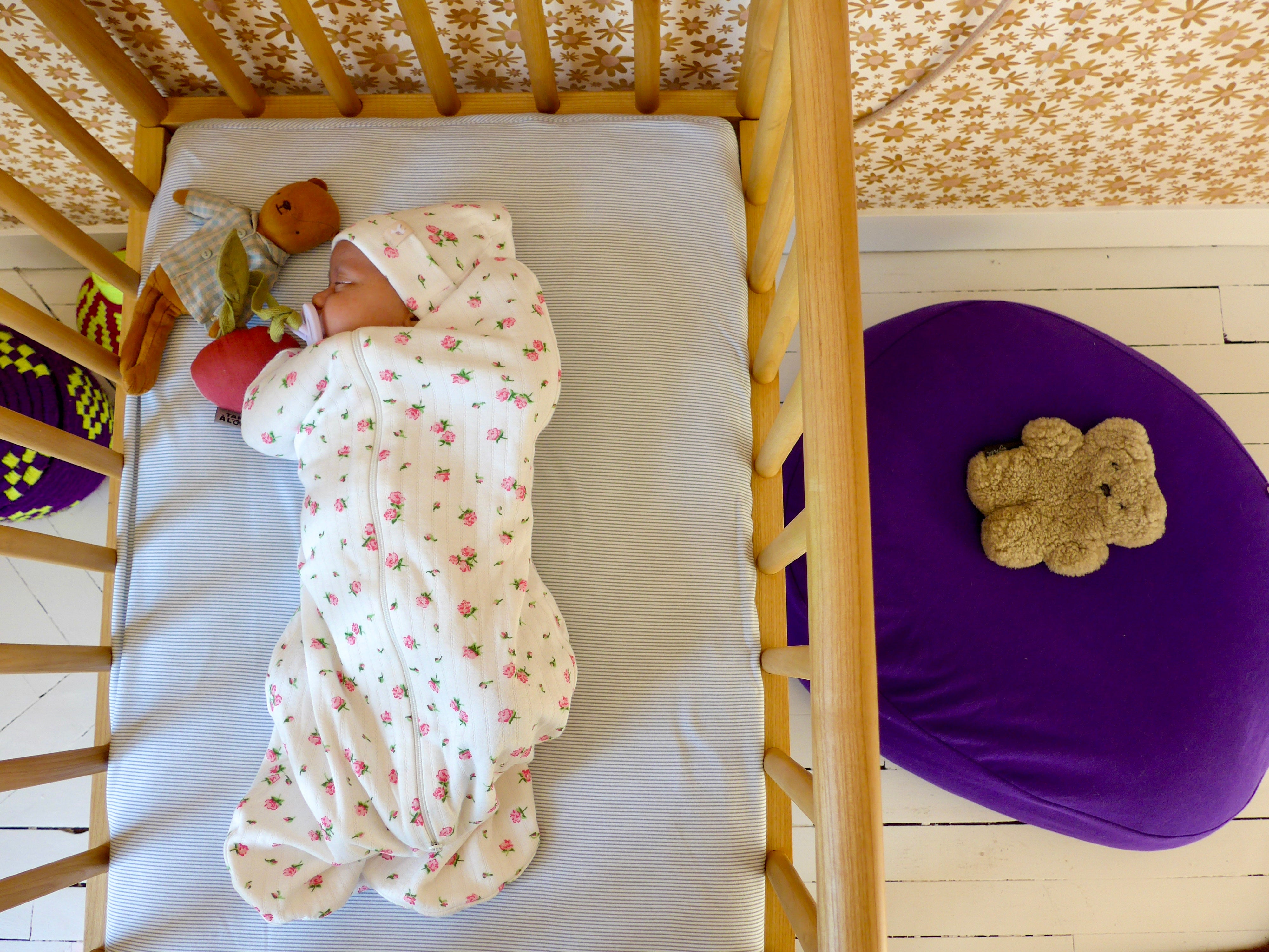 Bébé qui dort dans son lit à barreaux 