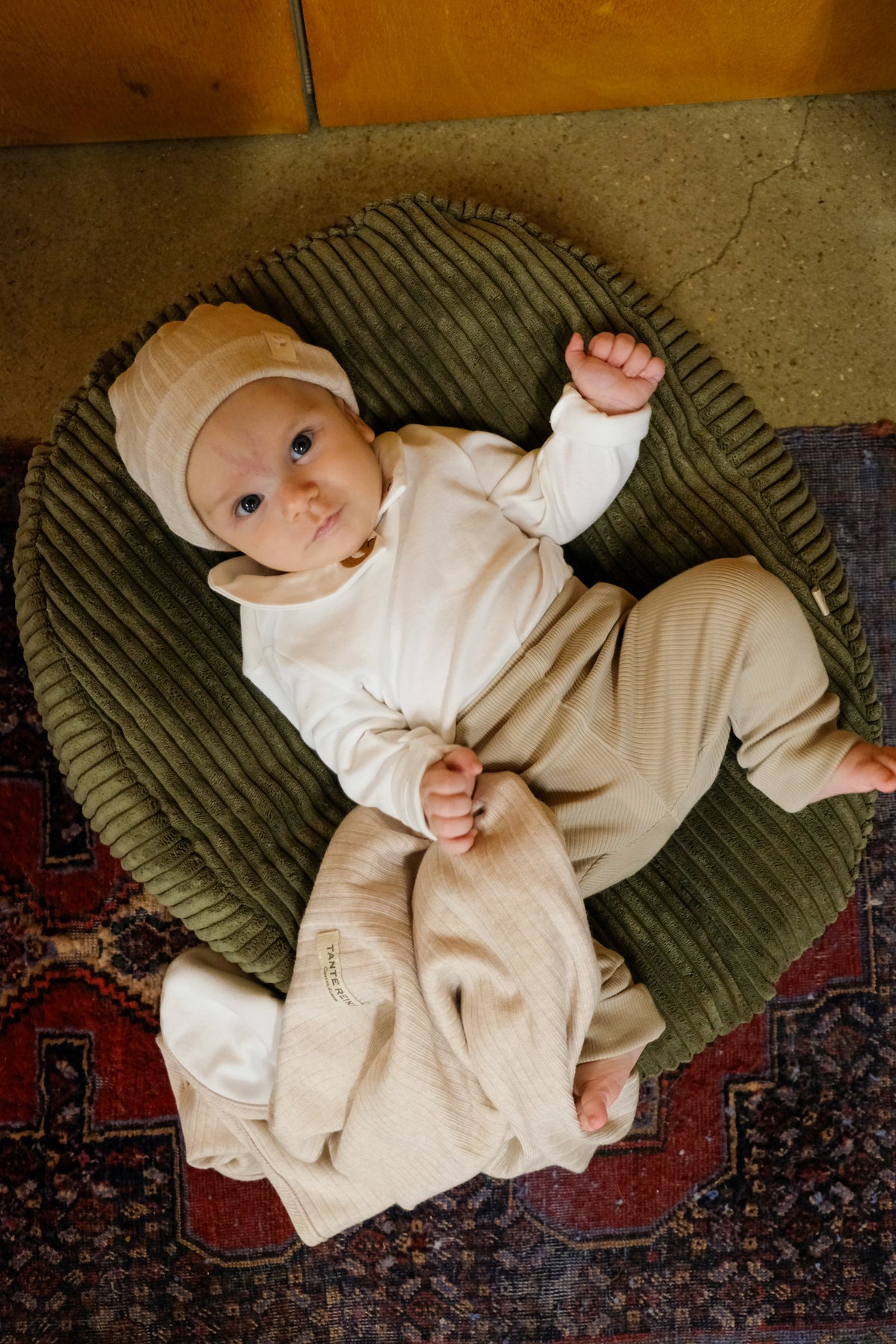 bebe allongé sur nid vert kaki matcha avec couverture et bonnet