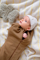 bébé se réveillant avec bonnet latte et emmailloteuse noisette