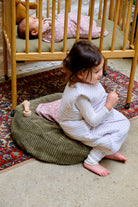 soeurs dont une allongée dans une emmailloteuses sur lit barreau et l'autre en gigoteuse à pieds sur nid bag matcha