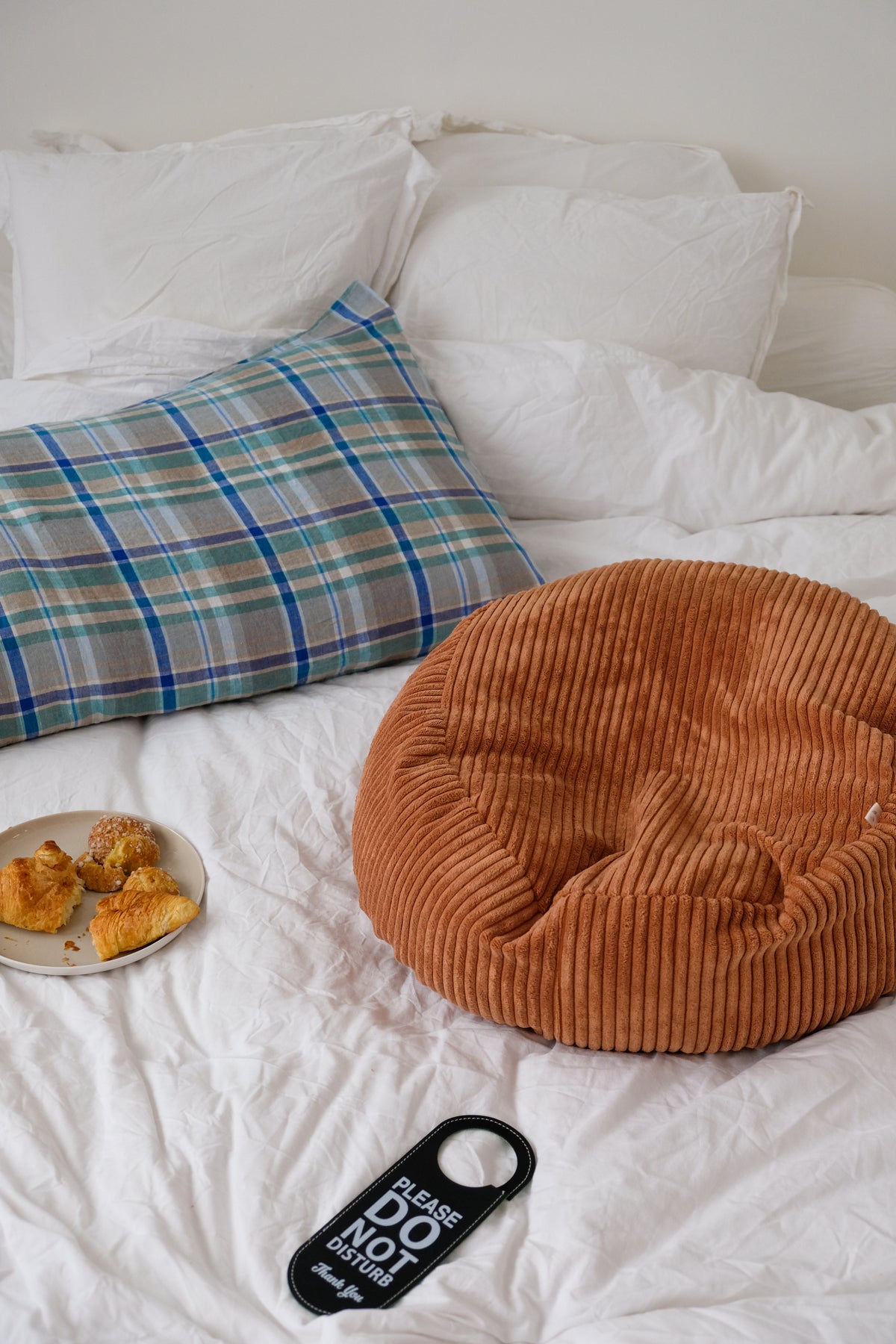 sur un lit coussin, croissant, nid bag